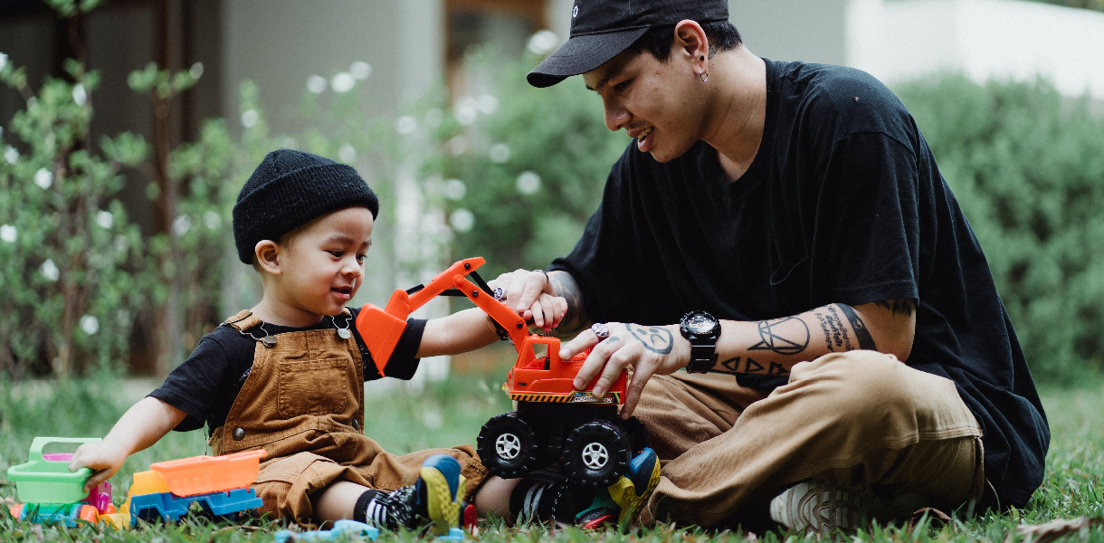 Father and Son Playing with Toy Cars Outdoors